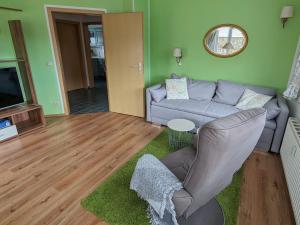 uma sala de estar com um sofá e uma televisão em Strandnest em Ostseebad Karlshagen