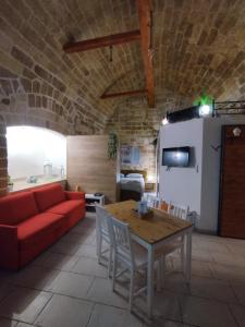 ein Wohnzimmer mit einem roten Sofa und einem Tisch in der Unterkunft Lullaby Room in Bari