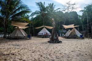 - un groupe de tentes et d'arbres sur une plage dans l'établissement Long Beach Camp, aux Îles Perhentian