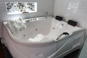 a white bath tub in a bathroom with a window at Hotel Risot in Bogotá