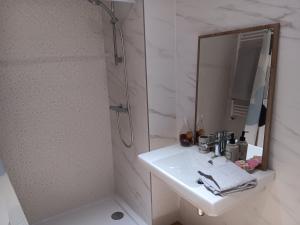 Baño blanco con lavabo y espejo en Habitacion Bolueta Home, en Bilbao