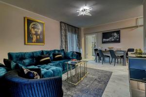 un soggiorno con divano blu e tavolo di LUXURY Apartament a Bucarest