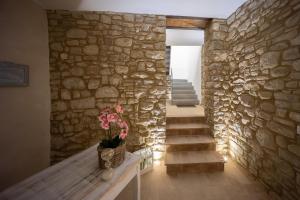 Habitación con pared de piedra y mesa con planta en Lombardi Rita - Colle S. Martino, en Asís