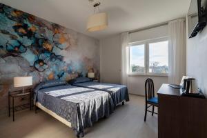 1 dormitorio con 1 cama y una pintura en la pared en Hotel Sorriso, en Lido de Venecia