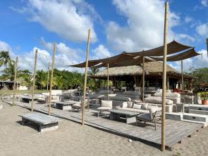 un pabellón con sofás y mesas en una playa en Blue Venao Beach Bliss Retreat / Condo E21, en Playa Venao