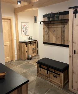 una cocina con armarios de madera y un banco en la pared en Chalet Schäftal 