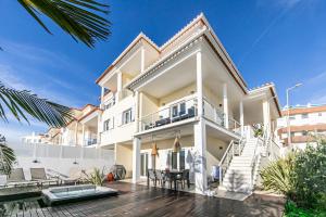 a white house with a balcony and a patio at Vibing & Liming Ericeira in Ericeira