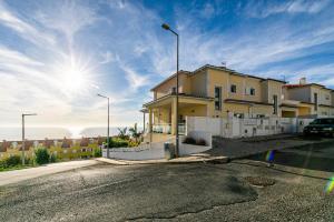 a house on a street with the sun in the sky at Vibing & Liming Ericeira in Ericeira