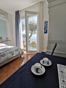 una camera con un letto e due piatti su un tavolo di B&B La Palafitta a Portovenere