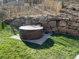 a bath tub sitting in the grass next to a stone wall at Chalet Schäftal in Langau