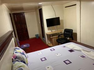 pokój hotelowy z łóżkiem i telewizorem w obiekcie Hotel La Rochelle w mieście Bonamakolo
