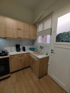 una cucina con armadi in legno e una grande finestra di Apartment Thisio ad Atene