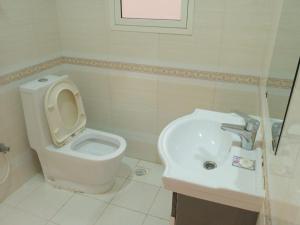 uma casa de banho com um WC e um lavatório em Star Dubai Apartment em Salalah
