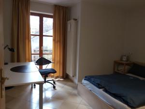 a bedroom with a bed and a desk and a window at Waldwinkel in Treuchtlingen