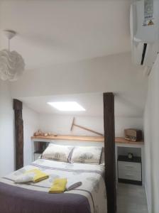 Un dormitorio con una cama con toallas amarillas. en Bejar Alojamiento La Plaza, en Béjar