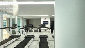 a gym with treadmills and treadleys in a building at Studio Batel com ótima localização in Curitiba