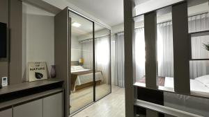 a room with a bedroom with a bed and a mirror at Studio Batel com ótima localização in Curitiba +33 photos