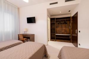 a hotel room with two beds and a closet at Hotel Sorriso in Venice-Lido
