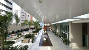 an indoor courtyard of a building with benches and plants at Studio Batel com ótima localização in Curitiba