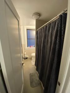 a bathroom with a toilet and a shower curtain at Large 3 bedroom perfect for families in New York