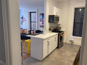 uma cozinha com armários brancos e um forno com placa de fogão em Large 3 bedroom perfect for families em Nova York