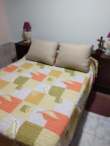 a bed with a colorful quilt on it in a room at Alquiler temporario amueblado in Junín
