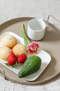 a plate with muffins and strawberries and a flower at Grunwaldzka 12 B22 - Easy-Rent Apartments - 50m od plaży in Pobierowo