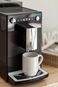 a coffee machine with a cup on a tray at Grunwaldzka 12 B22 - Easy-Rent Apartments - 50m od plaży in Pobierowo