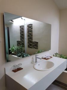 ein Badezimmer mit einem Waschbecken und einem großen Spiegel in der Unterkunft New Belitung Holiday Resort in Pasarbaru