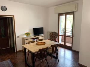 - un salon avec une table, des chaises et une télévision dans l'établissement Appartamento nel cuore della Valsassina, à Moggio