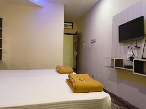 a room with two beds and a flat screen tv at Hotel Hara Rama Hare Krishna Rameswaram in Rāmeswaram