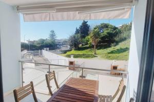 einen Balkon mit einem Tisch und Stühlen sowie Aussicht in der Unterkunft T2 Sesimbra a 100mts da Praia c/ Piscina in Sesimbra