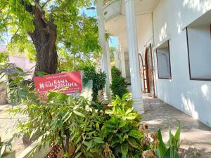 una señal frente a una casa con un árbol en Hotel Hara Rama Hare Krishna Rameswaram en Rāmeswaram