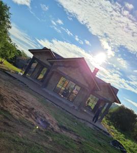 ein Haus auf einem Hügel mit der Sonne am Himmel in der Unterkunft Kichaka Cottages in Nyeri
