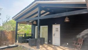 UcedaLa cabaña de Uceda的一间黑色房子,设有门廊和白色门