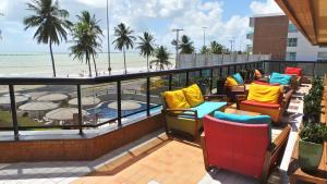 balcón con sillas y vistas a la playa en Flat Mobiliado, en João Pessoa