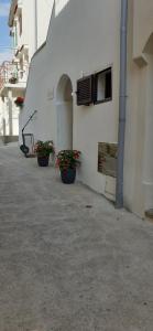three potted plants sitting on the side of a building at Old Town Baska in Baška