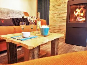 a living room with a table with wine glasses and a fireplace at "Le Cabanon cendré" petit chalet cosy au coeur de Gérardmer in Gérardmer