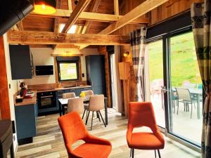 a kitchen and dining room with a table and chairs at "Le Cabanon cendré" petit chalet cosy au coeur de Gérardmer in Gérardmer +31 photos
