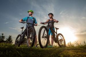 two people standing with their bikes in a field at k1 sporthotel in Kurort Oberwiesenthal