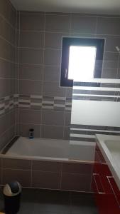 a bath tub in a bathroom with a window at Maison entière in Cérans-Foulletourte