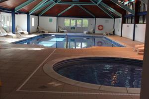 - une grande piscine dans un bâtiment dans l'établissement HG Holiday Home with indoor heated pool and close to the beach, à St Austell