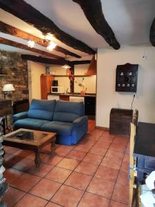 - un salon avec un canapé bleu et une table dans l'établissement Apartamentos rurales Casa Xepo, à Rengos