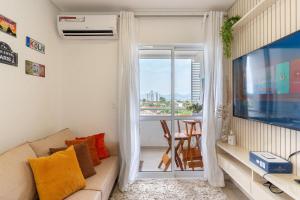 a living room with a couch and a window at EAO - Apartamentos completos em Joinville/SC in Joinville