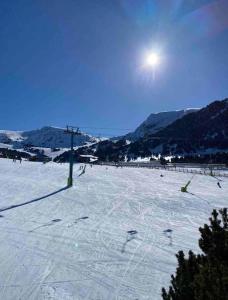 a snow covered field with the sun in the sky at Apartamento de montaña junto al rio ,pistas de ski y parque natural in Canillo