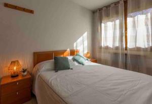 een slaapkamer met een bed met een laptop erop bij Apartamento de montaña junto al rio ,pistas de ski y parque natural in Canillo