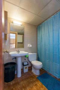 een badkamer met een wastafel, een toilet en een spiegel bij Apartamento de montaña junto al rio ,pistas de ski y parque natural in Canillo