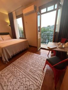 um quarto com uma cama, uma mesa e uma janela em NarPera Taksim Boutique Hotel em Istambul