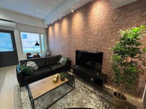 a living room with a couch and a brick wall at City Home Alvari, free parking, air conditioning in Kuopio