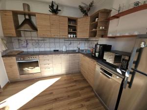 a kitchen with wooden cabinets and a stainless steel refrigerator at Zawoja Domek 1895 - Sauna i Bania in Zawoja